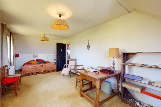 room / bedroom featuring lofted ceiling, light colored carpet, and an office area