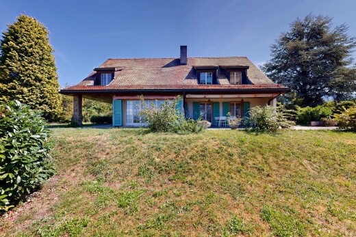outdoor house featuring a lawn, a chimney, and covered porch