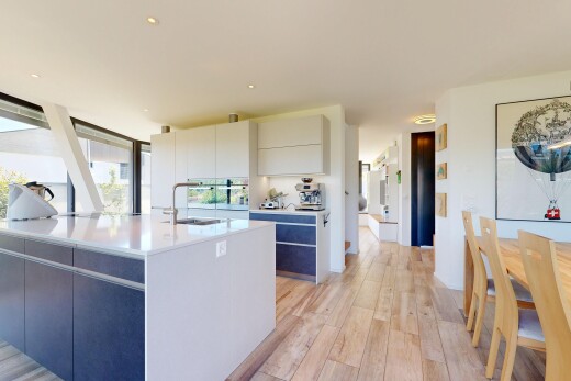 küche mit light countertops, wood finish floor, holzfußboden, flat panel cabinets, und schränke mit flachen paneelen