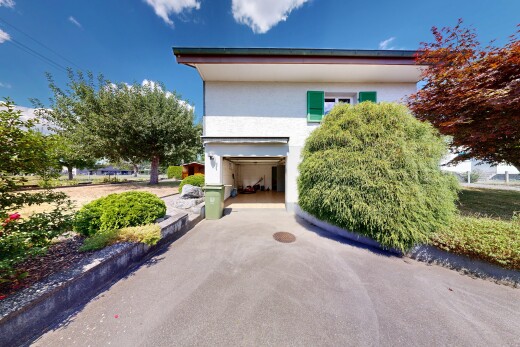 outdoor house featuring stucco siding, an attached garage, and asphalt driveway