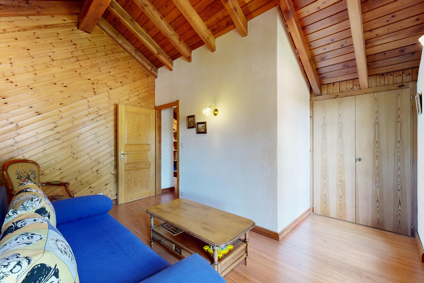 salon avec mur en bois, wood wall, plafond en bois, wood ceiling, et plafond à poutres