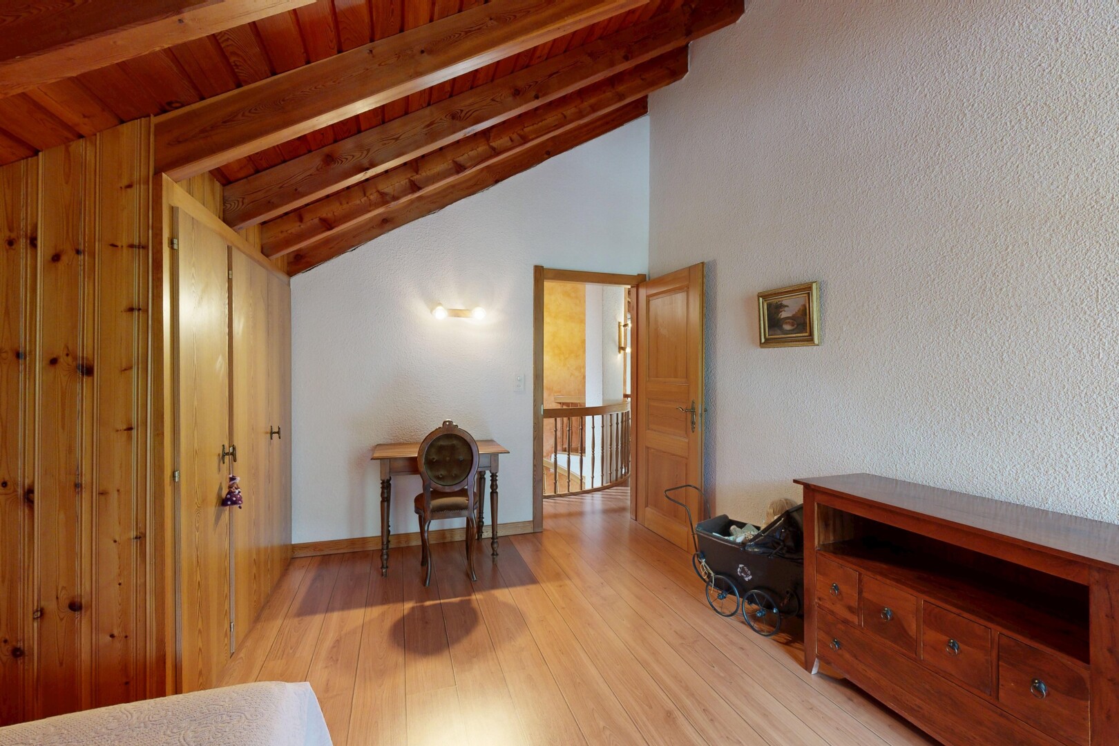 couloir avec sol en finition bois, wood finish floor, inside property, plafond voûté, et vaulted ceiling