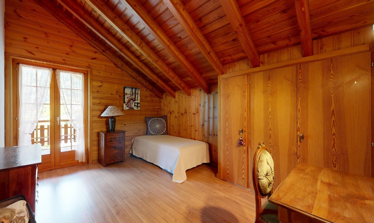 chambre avec plafond à poutres, beamed ceiling, sol en finition bois, wood finish floor, et mur en bois