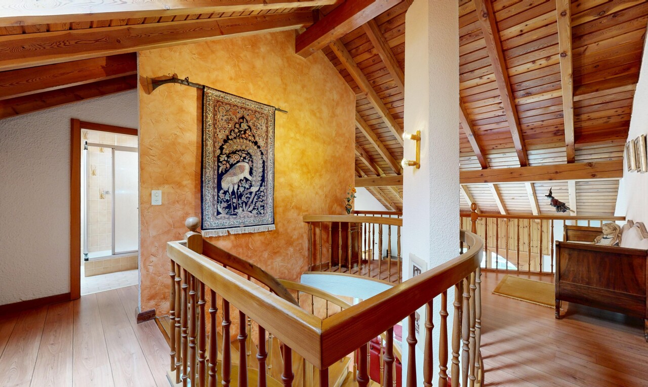 escaliers avec mezzanine, sol en finition bois, wood finish floor, plafond à poutres, et beamed ceiling