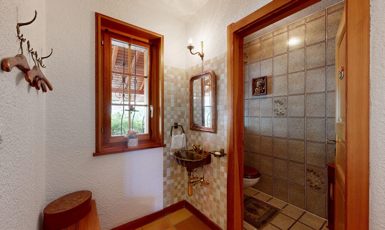 salle de bains avec mur texturé, textured wall, toilette, inside property, et miroir