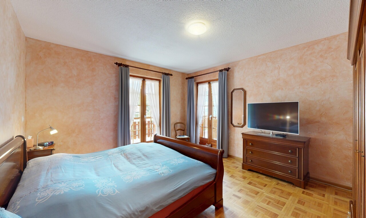 chambre avec sol en finition bois, wood finish floor, parquet floor, inside property, et télévision