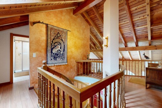 escaliers avec mezzanine, sol en finition bois, wood finish floor, plafond à poutres, et beamed ceiling