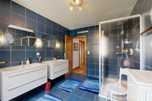 salle de bains avec mur en carrelage, tile wall, salle de bain complète, miroir, et deux lavabos simples