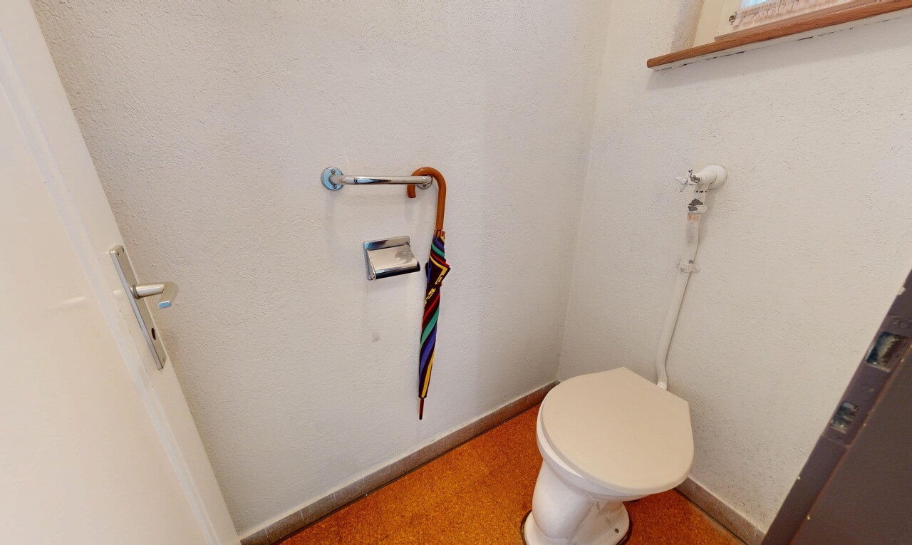 salle de bains avec toilette, baseboards wall, plinthes murales, inside property, et drywall