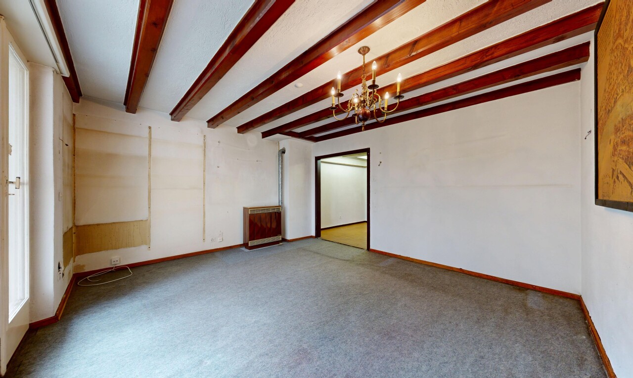 pièce vide avec lustre remarquable, inside community, cloison sèche, drywall, et plafond à poutres
