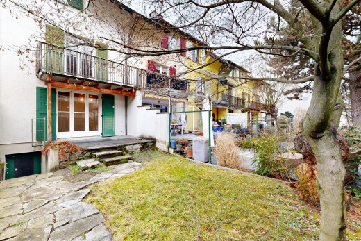 outdoor house featuring stucco siding, a balcony, a lawn, and a patio area