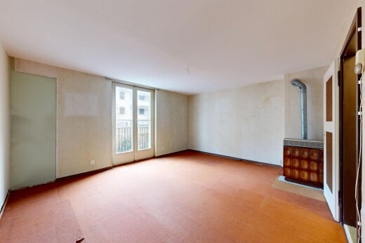 spare room with light carpet and a wood stove