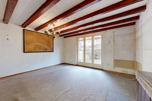 unfurnished room with suspended lighting, carpet flooring, and beamed ceiling