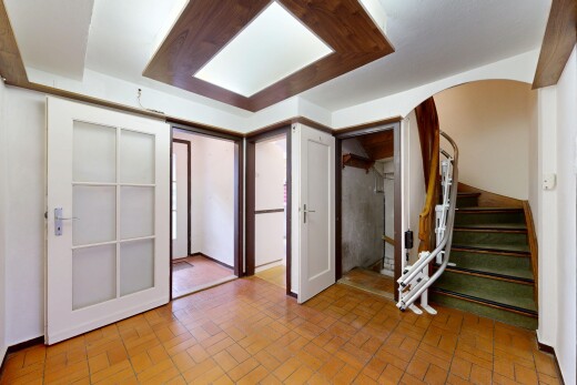 unfurnished room featuring stairs and brick patterned flooring