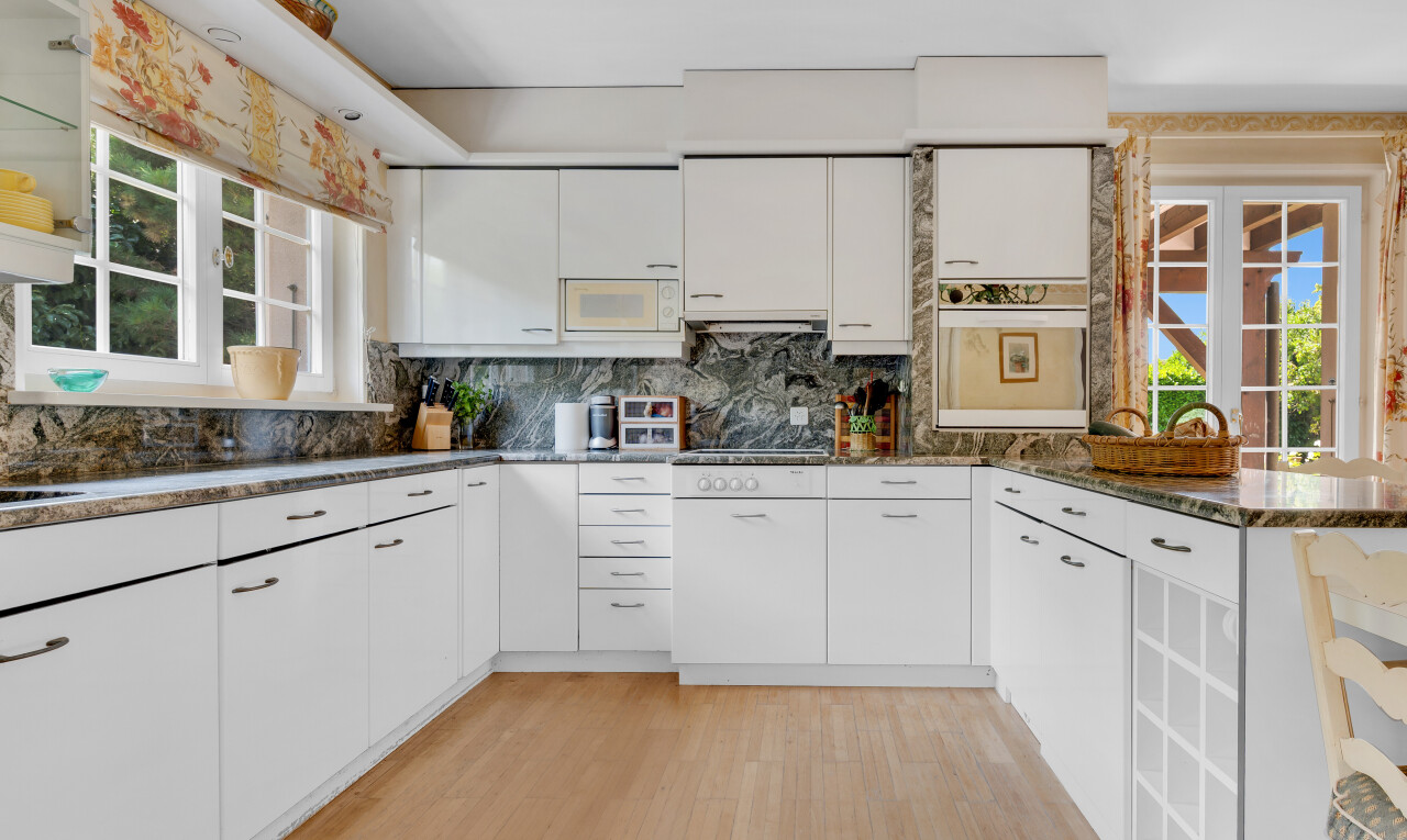 cuisine avec lumière naturelle, natural light, armoires blanches, sol en finition bois, et wood finish floor