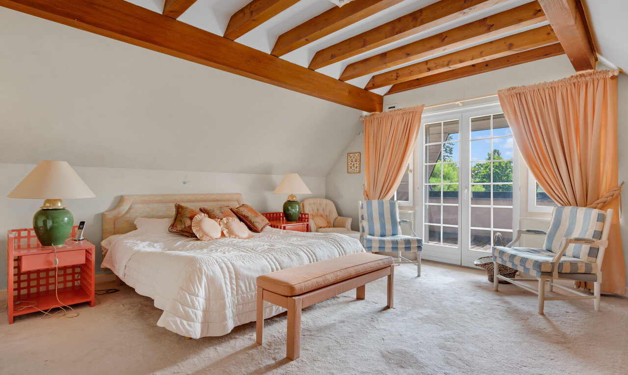 chambre avec beamed ceiling, plafond à poutres, natural light, lumière naturelle, et carpet