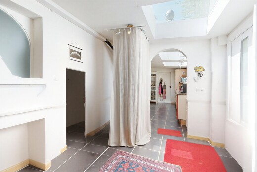 couloir avec passages en arc, cloison sèche, drywall, puits de lumière, et sol en carrelage