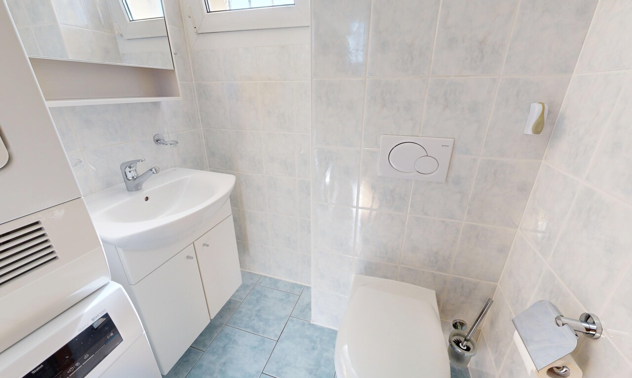 salle de bains avec tile wall, mur en carrelage, miroir, lavabo (ou coiffeuse selon le contexte), et tile floor