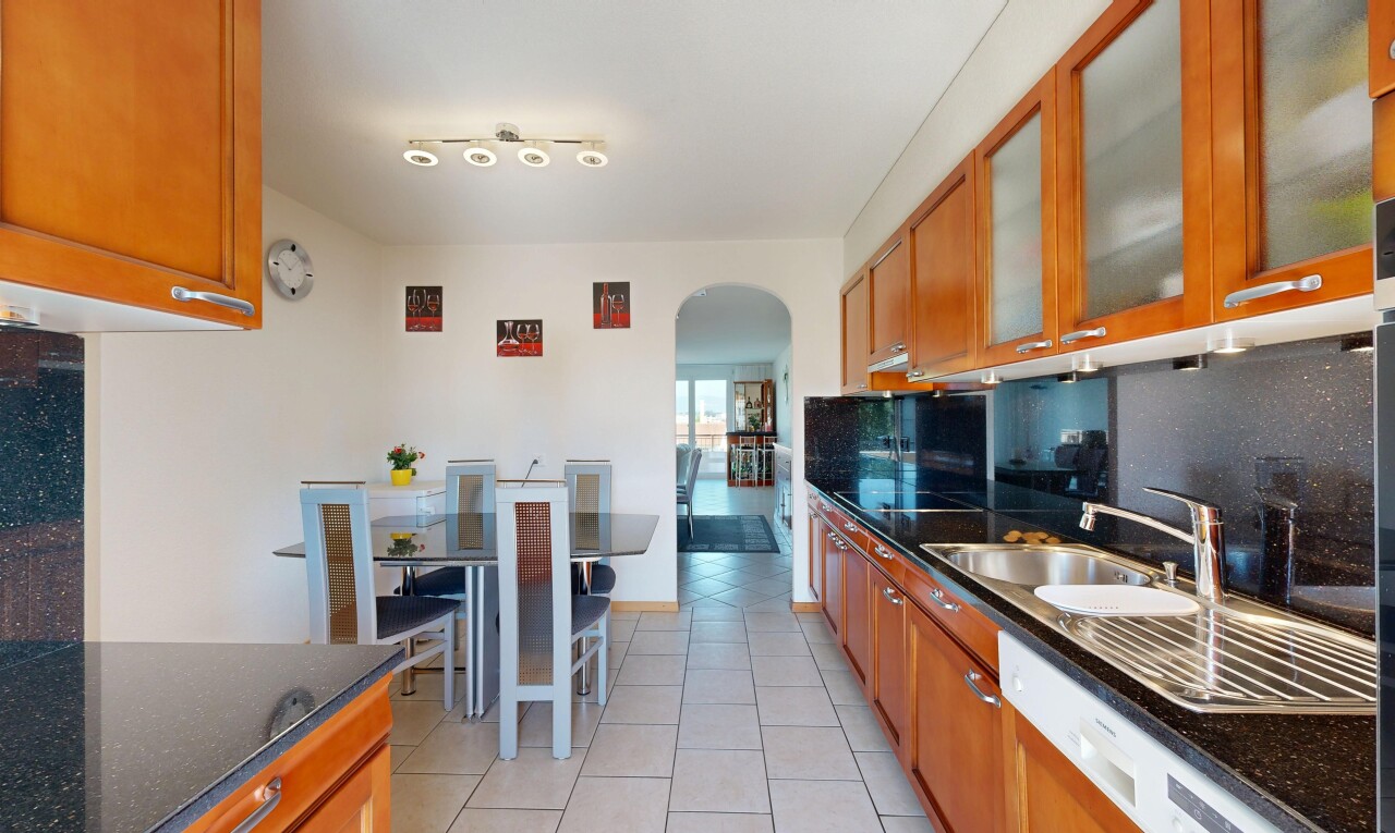 cuisine avec dark countertops, armoires marron moyen, medium brown cabinets, armoires avec insert en verre, et glass insert cabinets