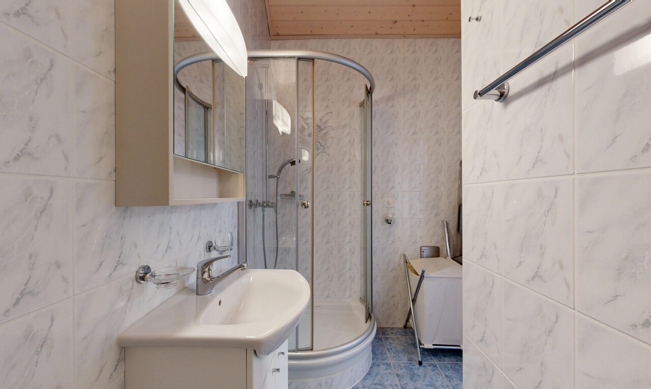 salle de bains avec miroir, mur en carrelage, tile wall, douche, et inside property