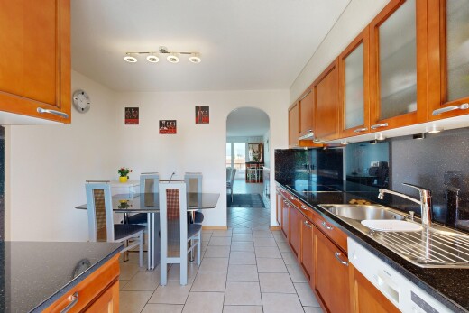 cuisine avec dark countertops, armoires marron moyen, medium brown cabinets, armoires avec insert en verre, et glass insert cabinets