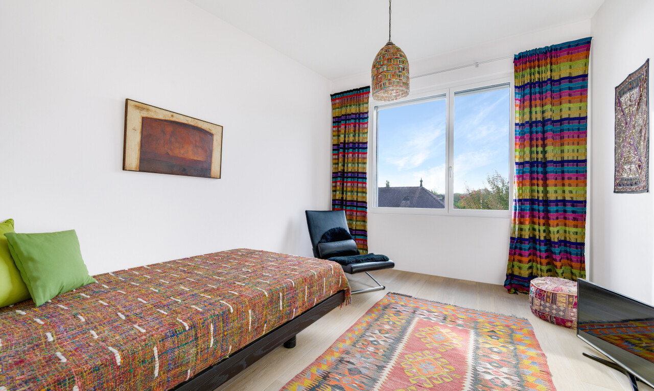 zimmer / schlafzimmer mit fernseher, gipskartonwand, drywall, natürliches licht, und natural light