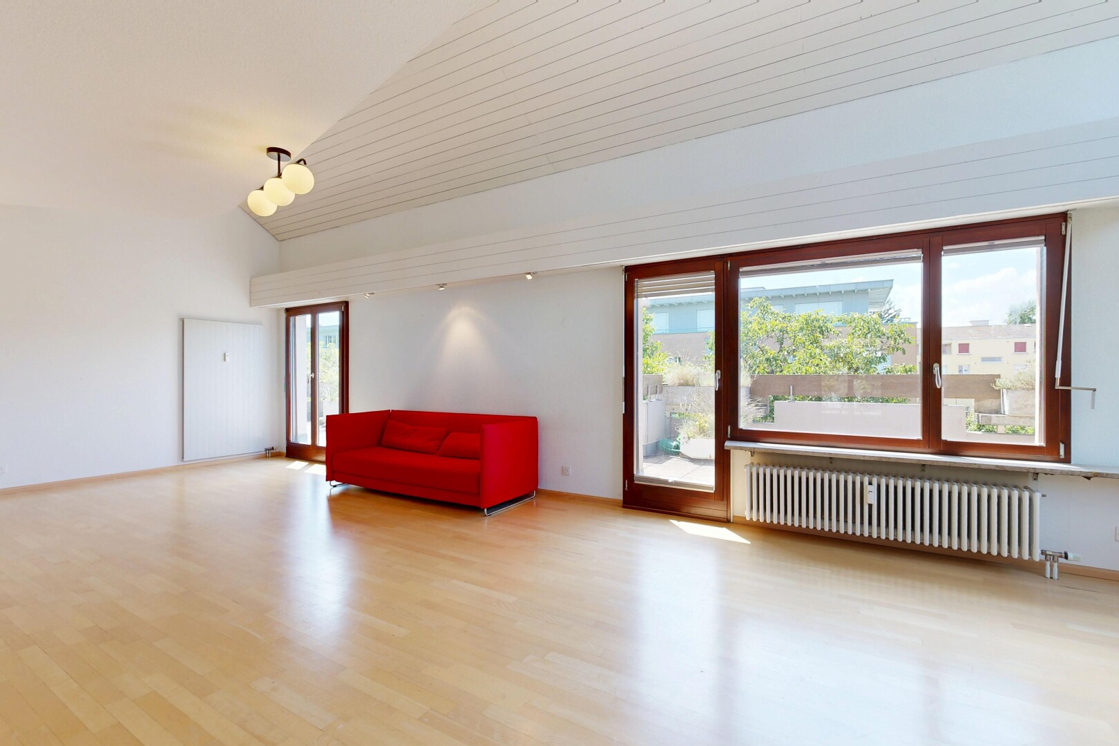 pièce vide avec sol en finition bois, wood finish floor, radiateur, lumière naturelle, et natural light