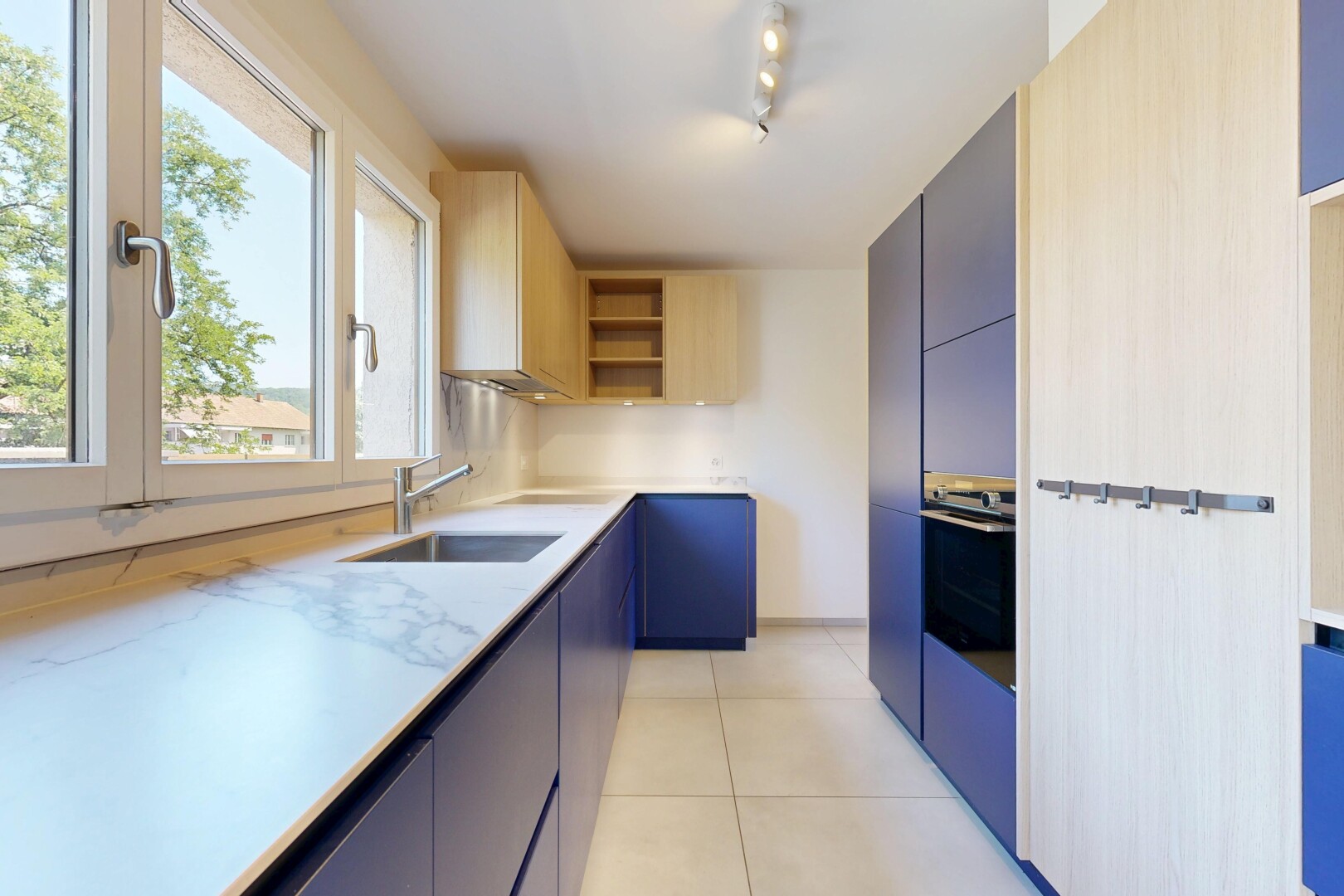 cuisine avec étagères ouvertes, open shelves, light floor, light countertops, et four