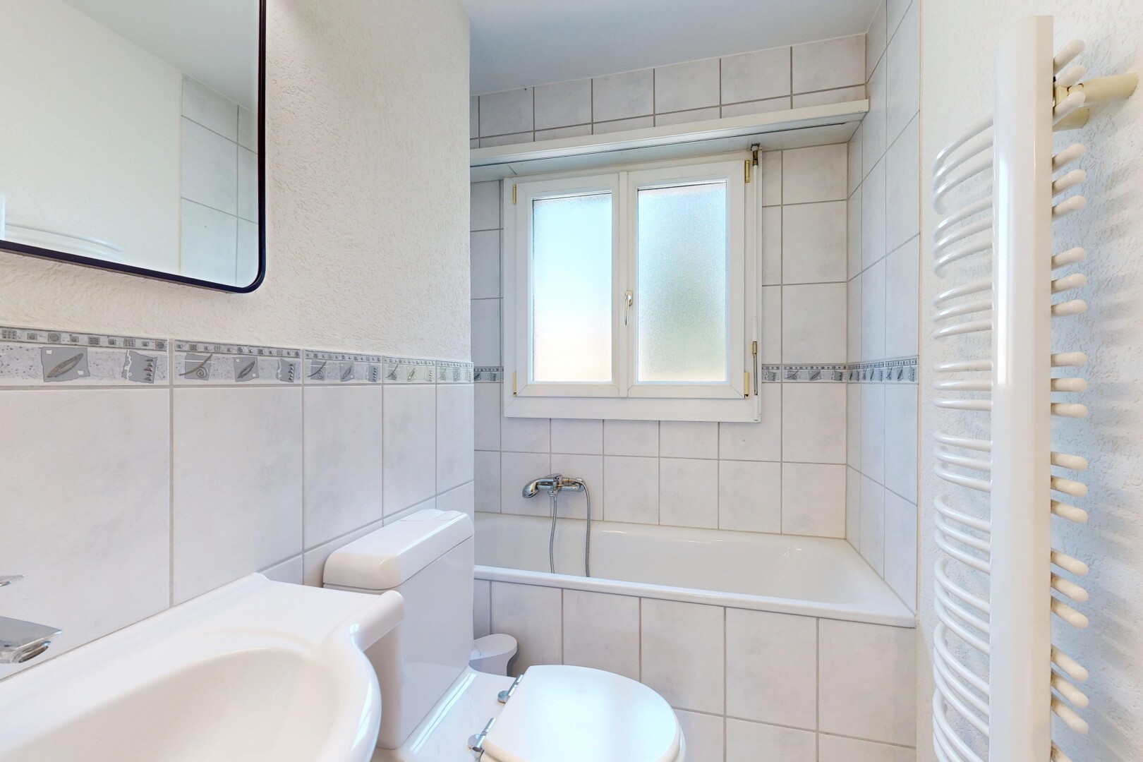salle de bains avec miroir, salle de bain complète, toilette, mur en carrelage, et tile wall