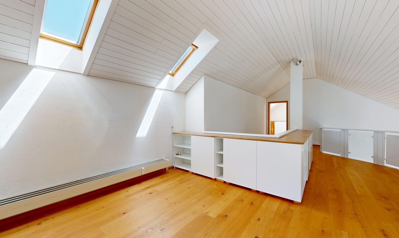 pièce vide avec puits de lumière, sol en finition bois, wood finish floor, inside property, et plafond voûté