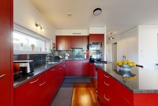küche mit dark countertops, rote schränke, red cabinets, inside property, und holzfußboden