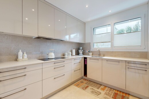 küche mit light countertops, light floor, flat panel cabinets, schränke mit flachen paneelen, und natural light