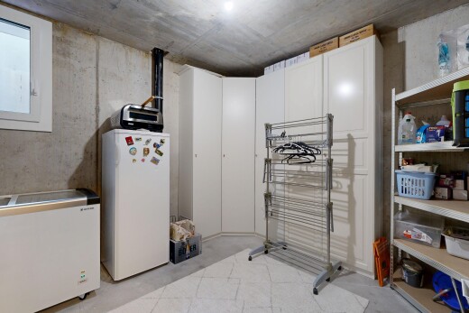 kitchen with white fridge, concrete flooring, freestanding refrigerator, and white cabinets