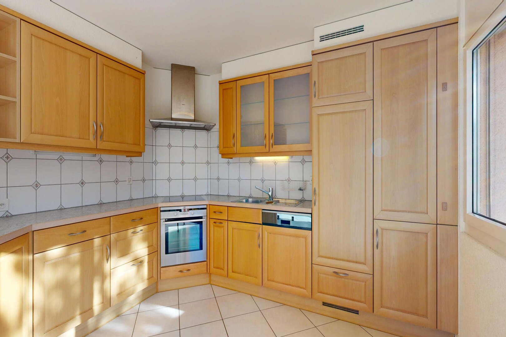 cuisine avec hotte, four, inside property, lave-vaisselle, et plans de travail