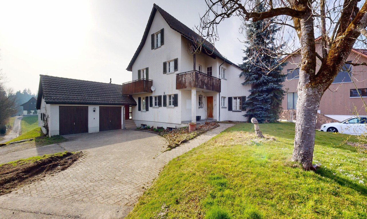 außenansicht mit balkon, property visible, auffahrt, garage angeschlossen, und rasen