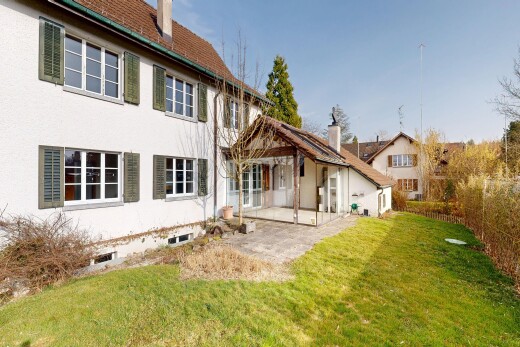 façade avec property visible, terrasse, bardage en stuc, pelouse, et cheminée