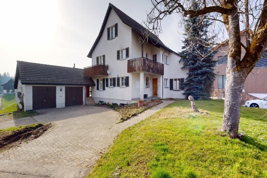 außenansicht mit balkon, property visible, auffahrt, garage angeschlossen, und rasen