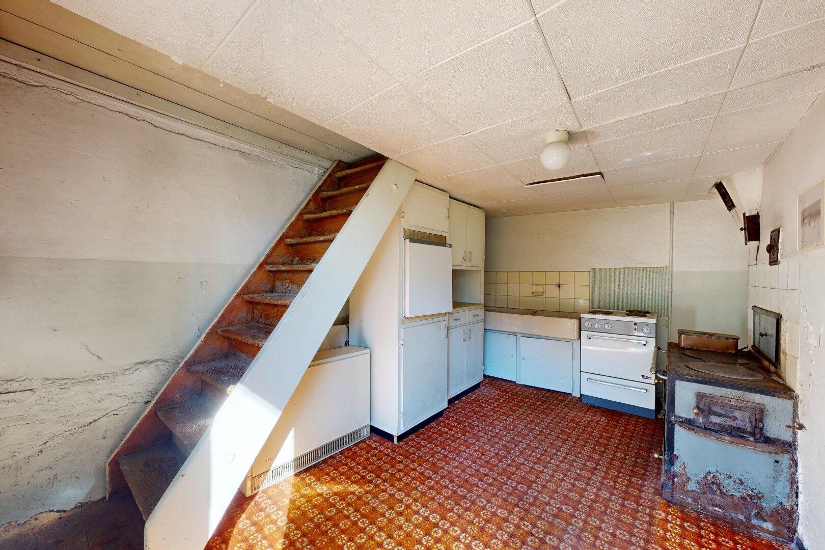 cuisine avec drywall, cloison sèche, cuisinière, dark floor, et inside property