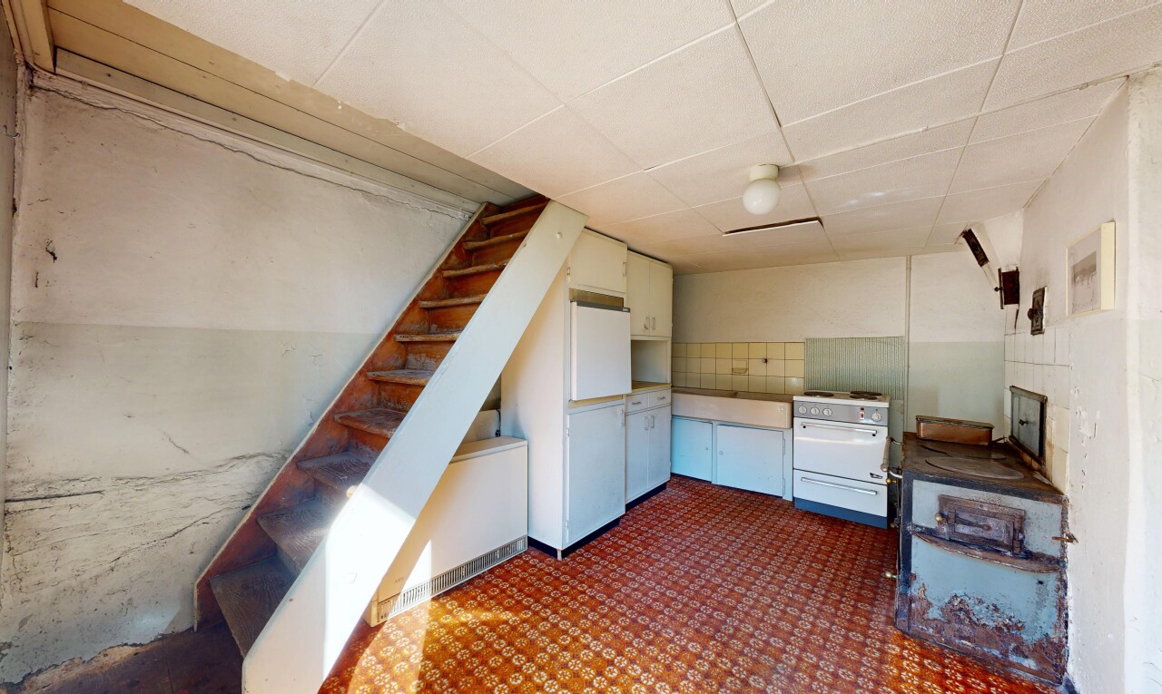 cuisine avec drywall, cloison sèche, cuisinière, dark floor, et inside property