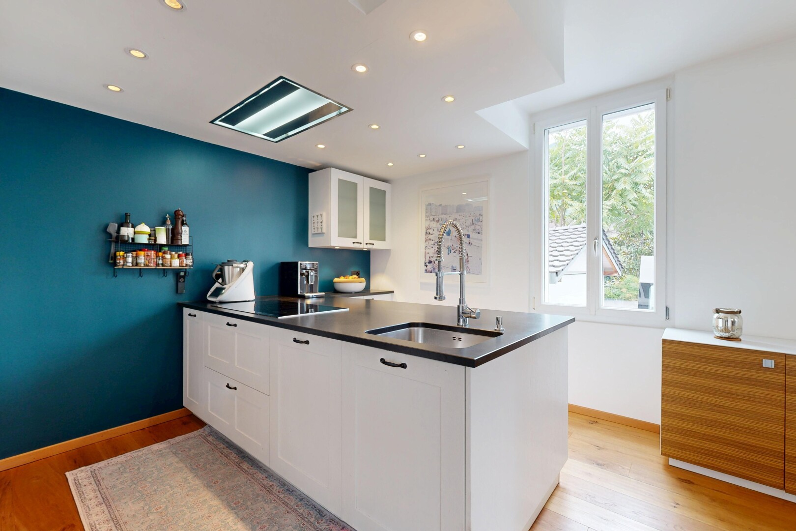 cuisine avec armoires blanches, armoires avec insert en verre, natural light, lumière naturelle, et wood finish floor
