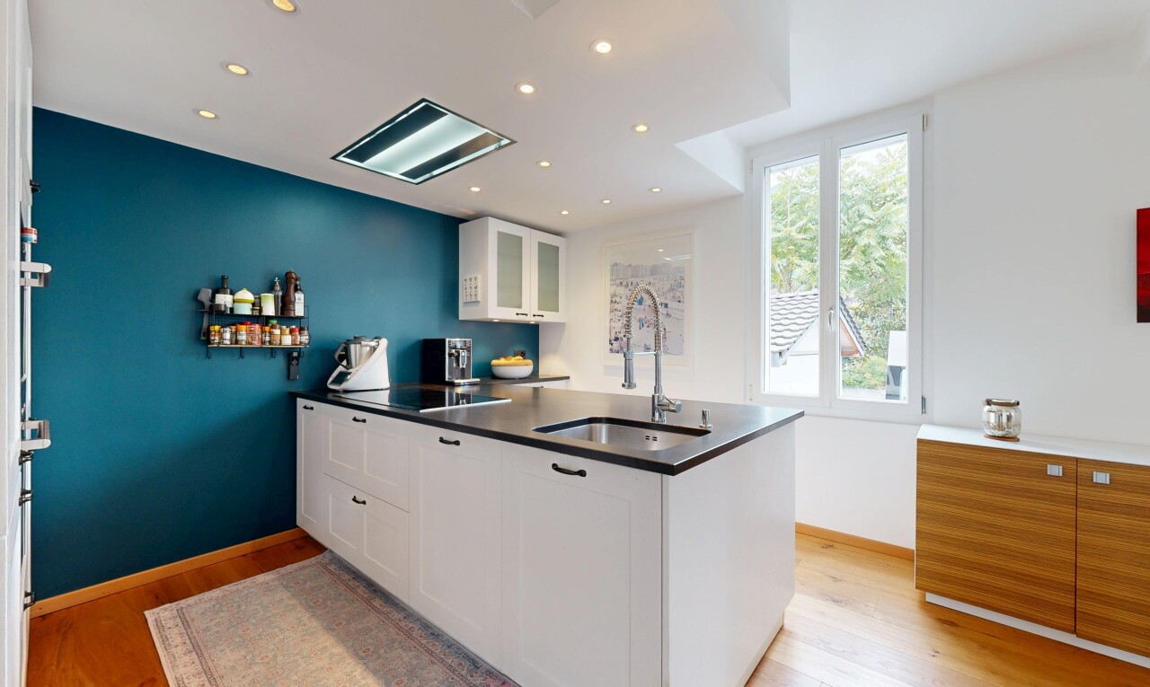 cuisine avec armoires blanches, armoires avec insert en verre, natural light, lumière naturelle, et wood finish floor