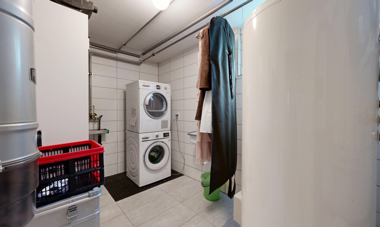 buanderie avec inside property, tile floor, sol en carrelage, lave-linge et sèche-linge superposés, et buanderie