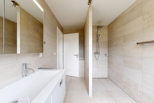 salle de bains avec mur en carrelage, tile wall, miroir, lavabo (ou coiffeuse selon le contexte), et douche