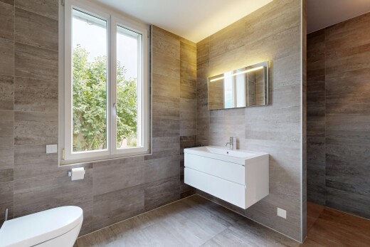 salle de bains avec mur en carrelage, tile wall, lavabo (ou coiffeuse selon le contexte), lumière naturelle, et natural light