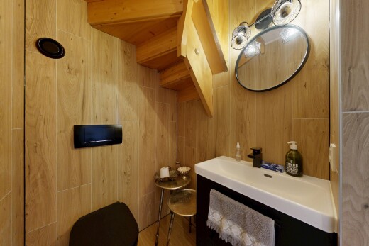 salle de bains avec miroir, inside property, lavabo (ou coiffeuse selon le contexte), mur en bois, et wood wall