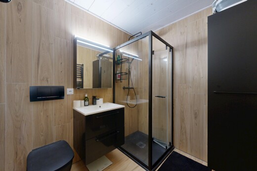 salle de bains avec mur en bois, wood wall, miroir, salle de bain complète, et lavabo (ou coiffeuse selon le contexte)