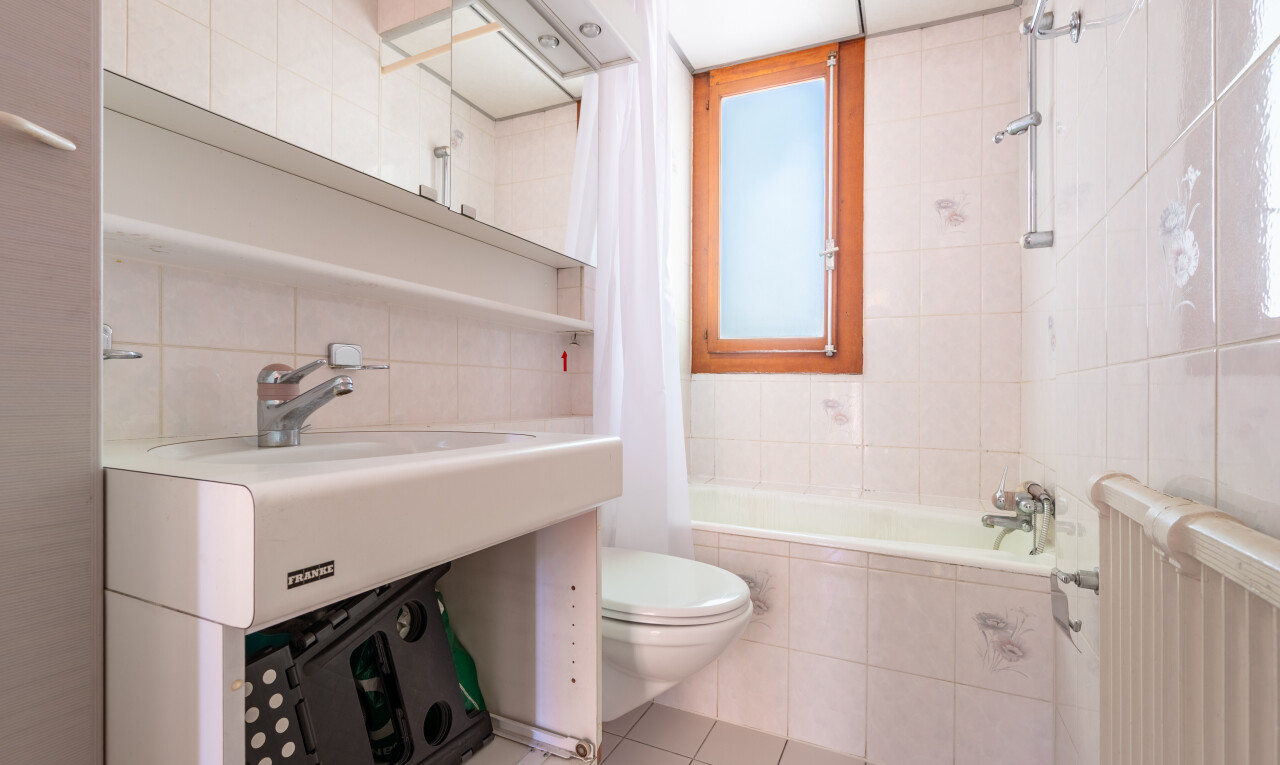 salle de bains avec radiateur, mur en carrelage, tile wall, inside property, et sol en carrelage