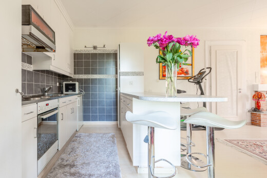 küche mit dunstabzugshaube, ofen, inside property, weiße schränke, und mikrowelle