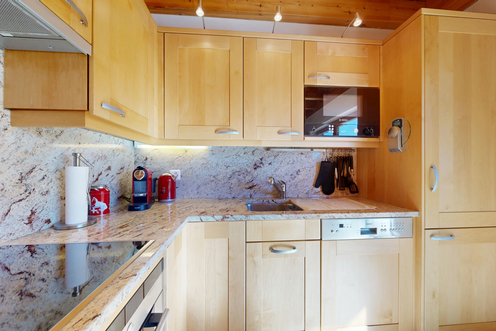 kitchen featuring light wood finish cabinets, black electric cooktop, light stone counters, white dishwasher, and wall oven