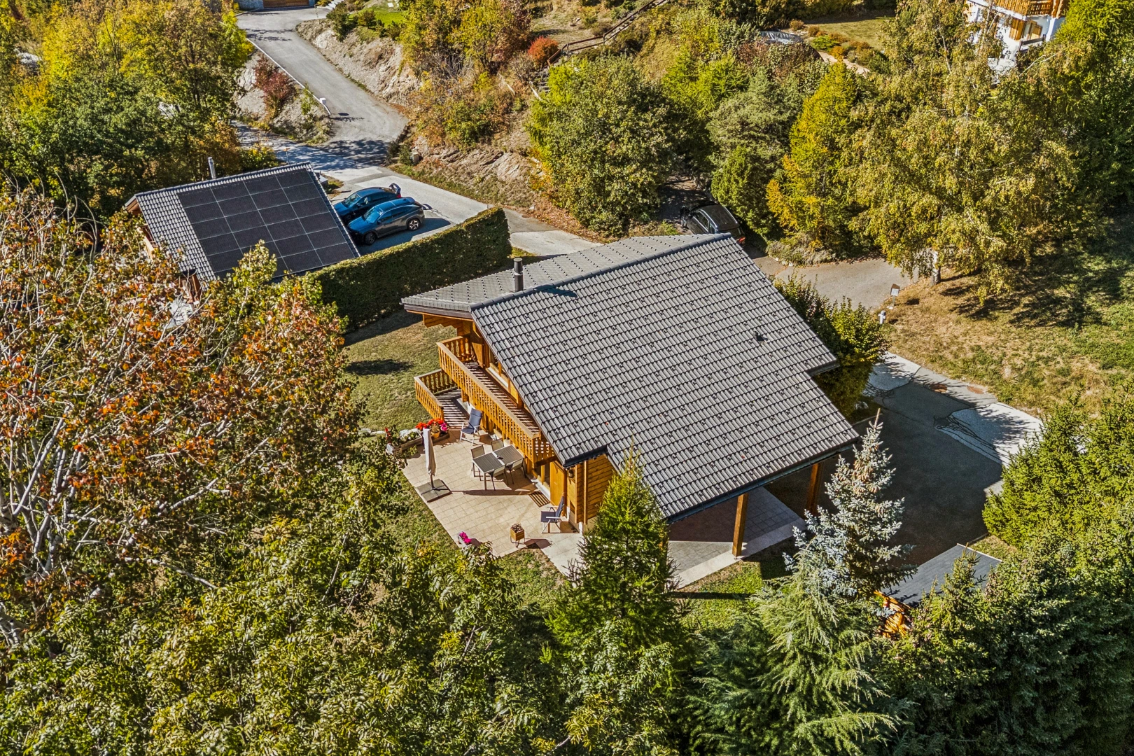 view of home with a patio, solar panels, and view of scattered trees